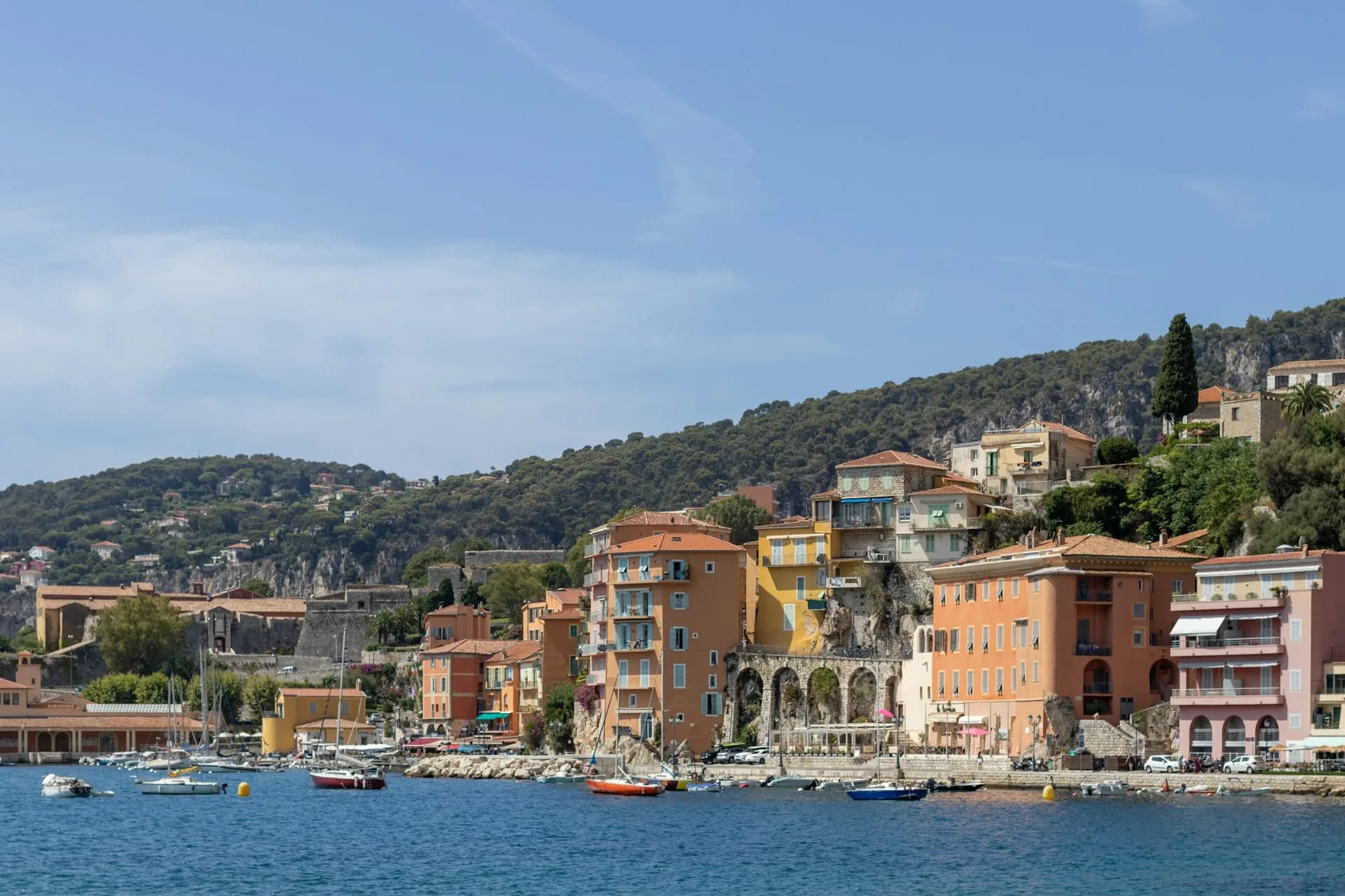Façades colorées de Villefranche-sur-Mer et petits bateaux au mouillage dans la rade